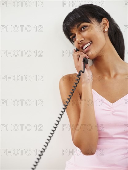 Young woman talking on phone. Photographe : momentimages