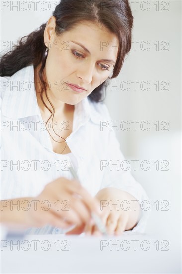 Woman looking at blueprints. Photographe : momentimages