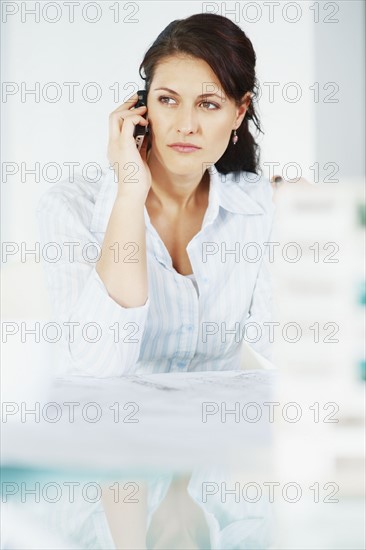 Woman talking on cellular phone. Photographe : momentimages