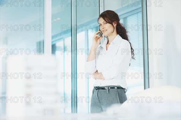 Woman talking on cellular phone. Photographe : momentimages