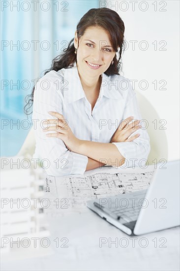 Woman sitting at desk. Photographe : momentimages