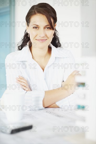 Woman sitting at desk. Photographe : momentimages