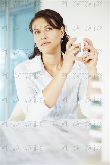 Woman sitting at desk. Photographe : momentimages