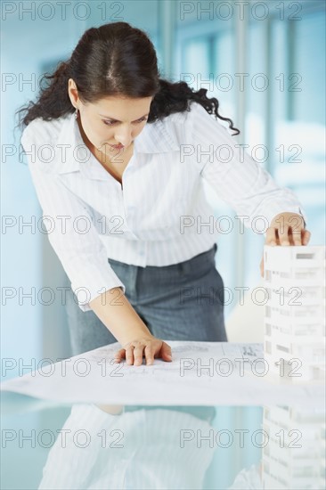 Woman looking at architectural model. Photographe : momentimages