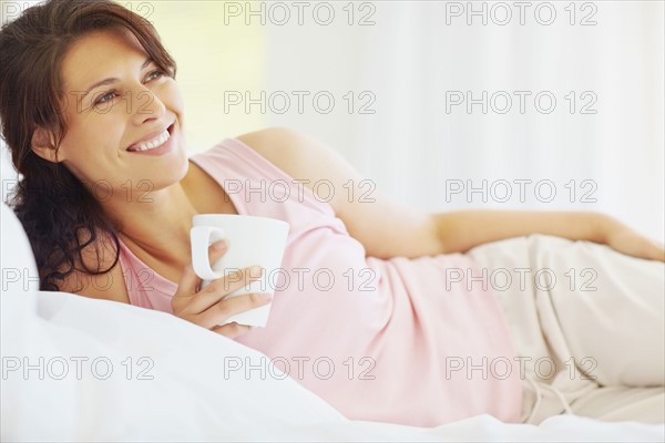 Woman relaxing with a coffee. Photographe : momentimages