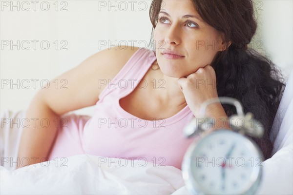 Woman thinking in the bedroom. Photographe : momentimages