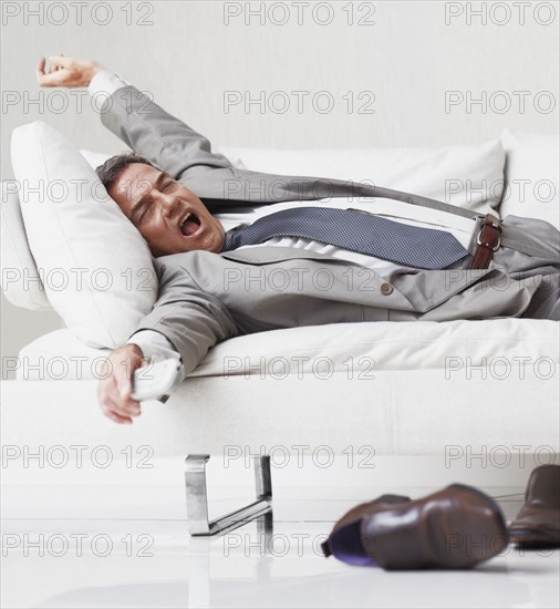 Businessman resting on couch. Photographe : momentimages