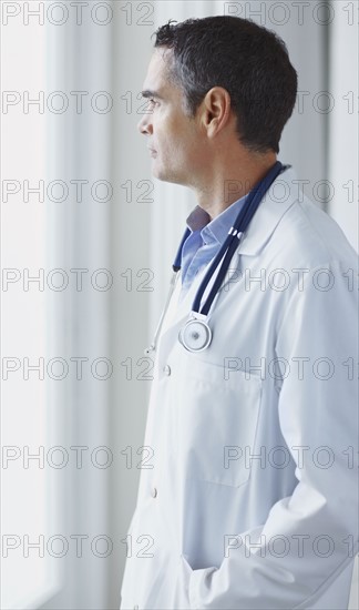 Doctor looking out window. Photographe : momentimages