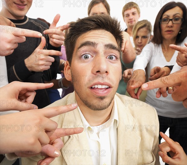 Group of people pointing at one person. Photographe : momentimages