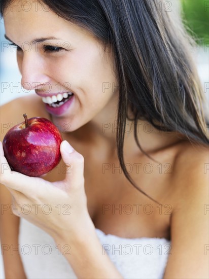 Woman eating an apple. Photographe : momentimages