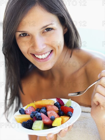 Woman eating fresh fruit. Photographe : momentimages