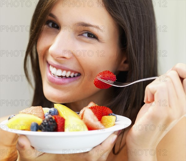 Woman eating fresh fruit. Photographe : momentimages