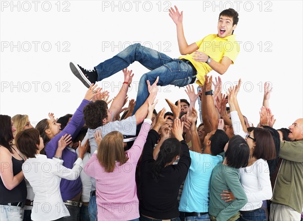 Group of people carrying man. Photographe : momentimages