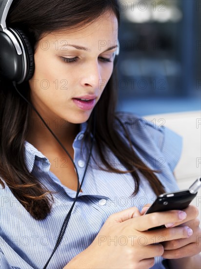 Woman listening to music on headphones. Photographe : momentimages