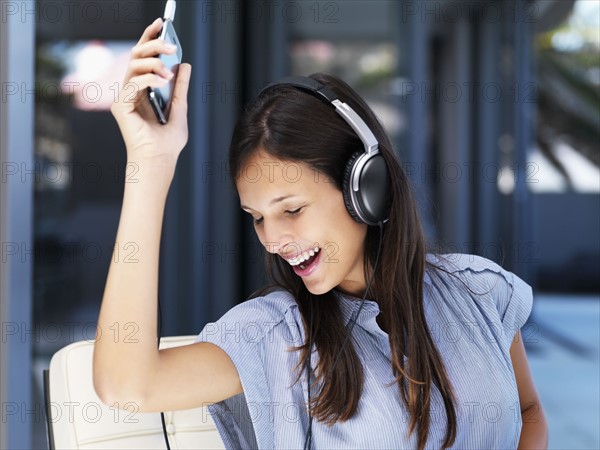 Woman listening to music on headphones. Photographe : momentimages