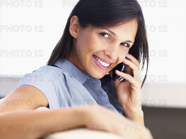 Woman talking on cellular phone. Photographe : momentimages