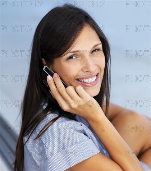 Woman talking on cellular phone. Photographe : momentimages