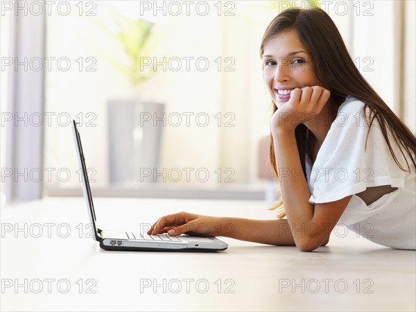 Woman typing on laptop. Photographe : momentimages