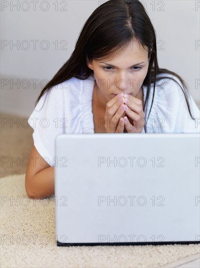 Woman looking at laptop. Photographe : momentimages