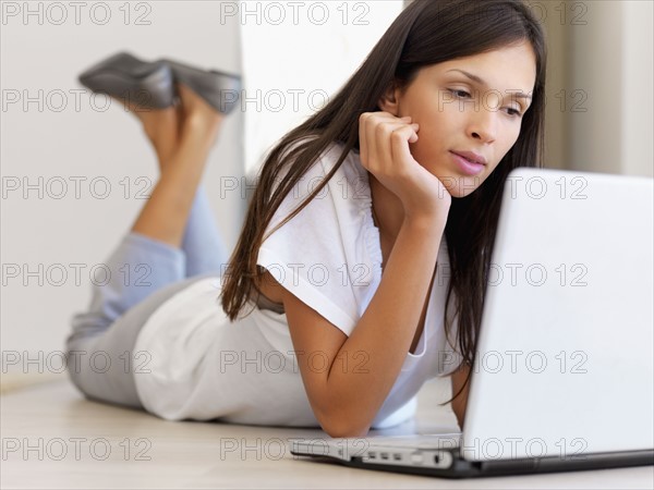 Woman looking at laptop. Photographe : momentimages