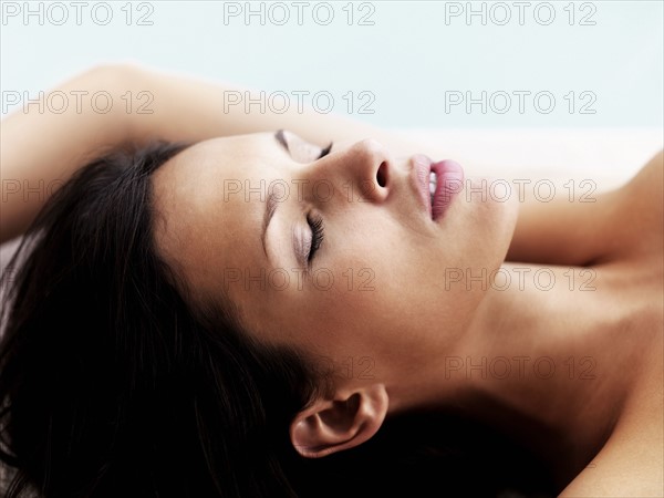 Woman relaxing by pool. Photographe : momentimages