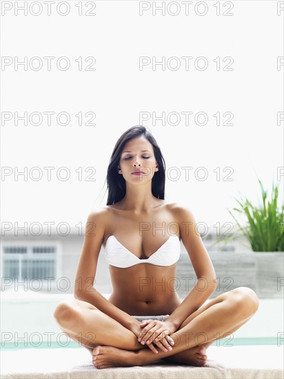 Woman relaxing by pool. Photographe : momentimages