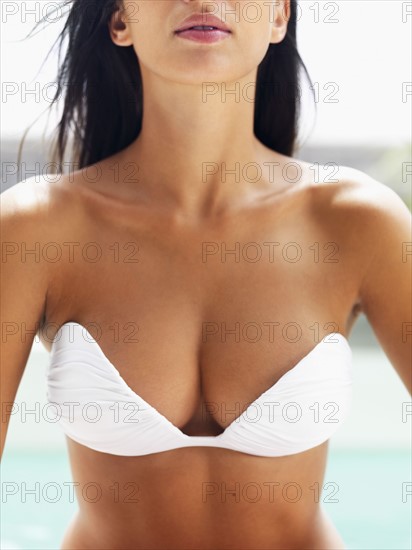 Voluptuous woman wearing strapless bikini top. Photographe : momentimages