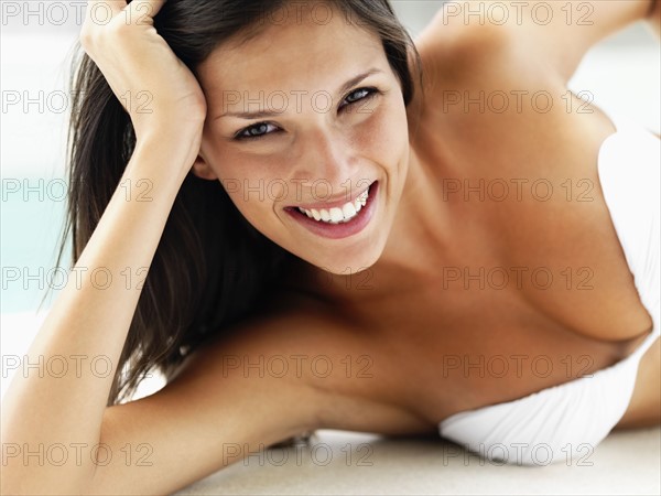 Woman relaxing by pool. Photographe : momentimages