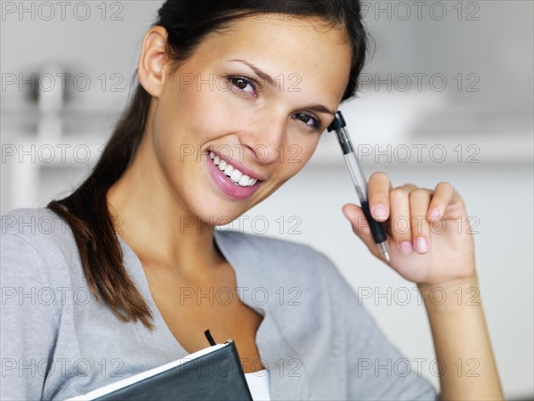 Woman writing in notebook. Photographe : momentimages