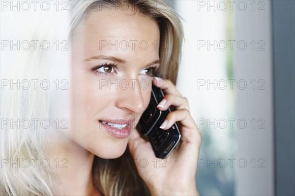 Woman talking on cellular phone. Photographe : momentimages