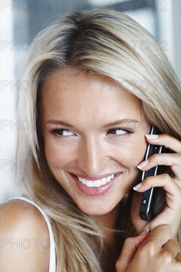 Woman talking on cellular phone. Photographe : momentimages