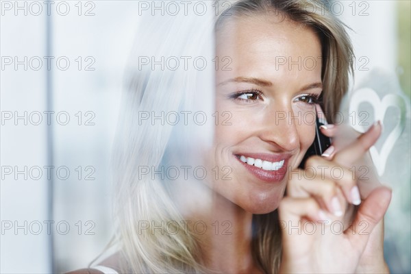 Woman talking on cellular phone. Photographe : momentimages