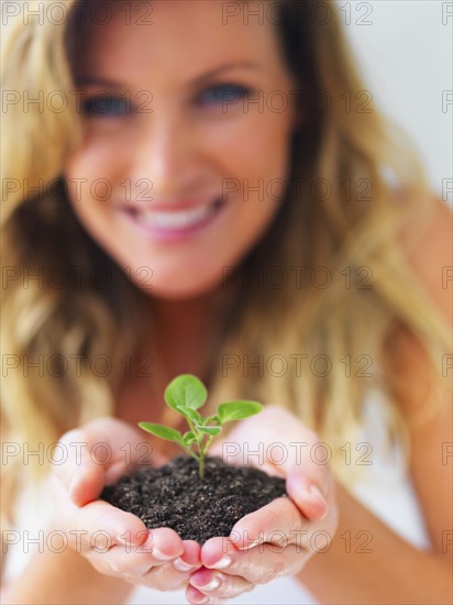 Hands holding sapling. Photographe : momentimages