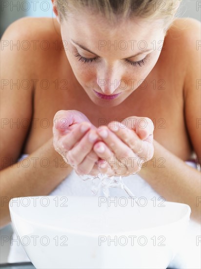 Woman washing her face. Photographe : momentimages