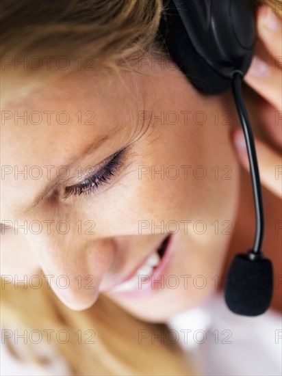 Receptionist wearing headset. Photographe : momentimages