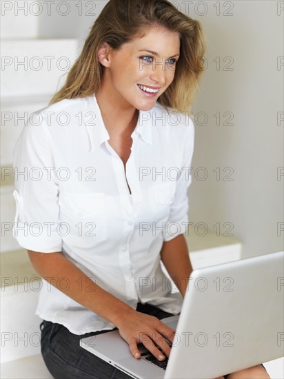 Woman working on laptop. Photographe : momentimages