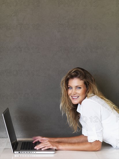 Woman working on laptop. Photographe : momentimages