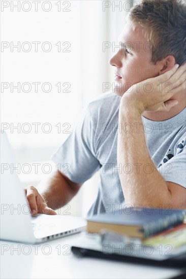 Young man daydreaming. Photographe : momentimages