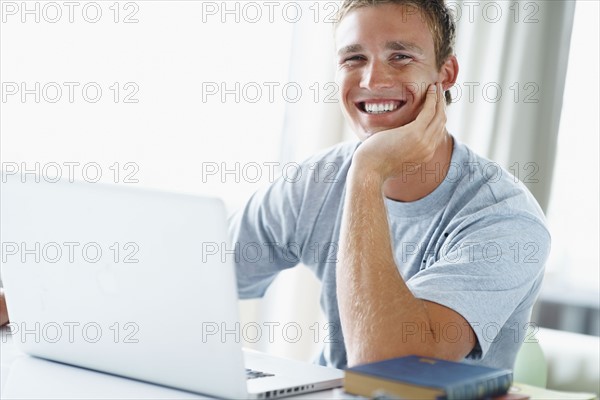 Young man working on laptop. Photographe : momentimages