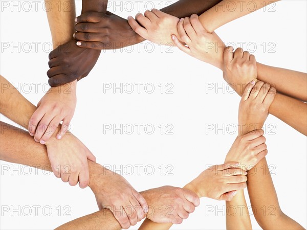 Clasped hands in a circle. Photographe : momentimages