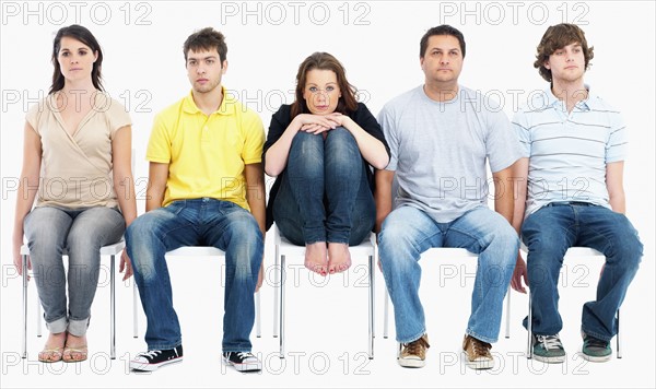 Bored people sitting on chairs. Photographe : momentimages