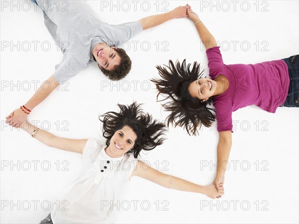 Friends holding hands in a circle. Photographe : momentimages