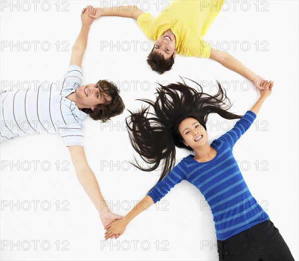 Friends holding hands in a circle. Photographe : momentimages