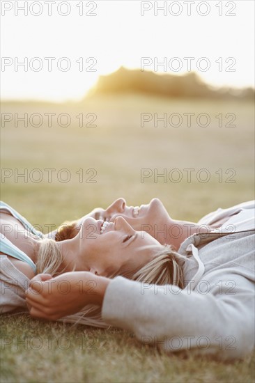 Couple relaxing on the grass. Photographe : momentimages