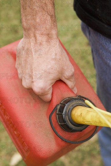 Hand holding gas can. Photographe : Stewart Cohen