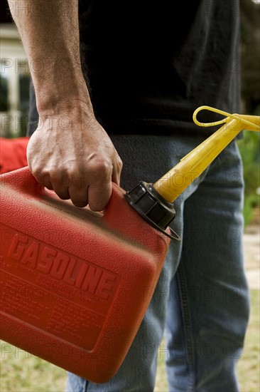 Hand holding gas can. Photographe : Stewart Cohen