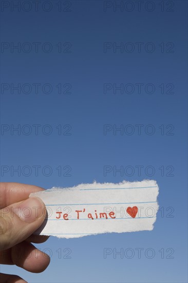 Hand holding I love you note written in French. Photographe : David Engelhardt