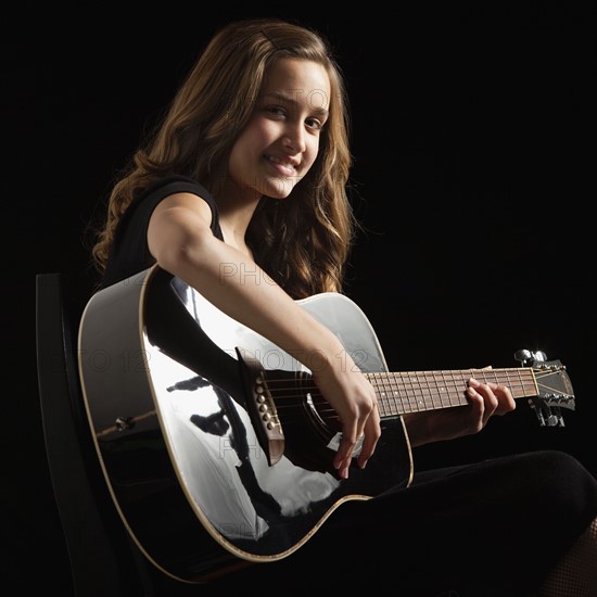 Young woman playing guitar. Photographe : Mike Kemp