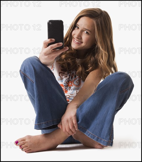 Young girl holding cellular phone. Photographe : Mike Kemp