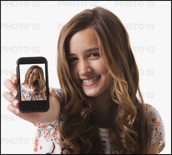 Young girl holding cellular phone. Photographe : Mike Kemp